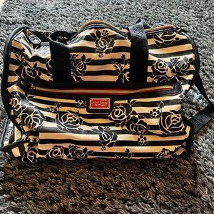 A black and white floral Betsey Johnson duffel bag.